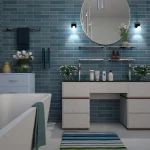 A modern bathroom with blue brick tile walls, a round mirror, and a white vanity with shelves holding various toiletries. A bathtub is on the left, and a colorful striped rug adds a pop of color on the floor. Towels and plants decorate the space.